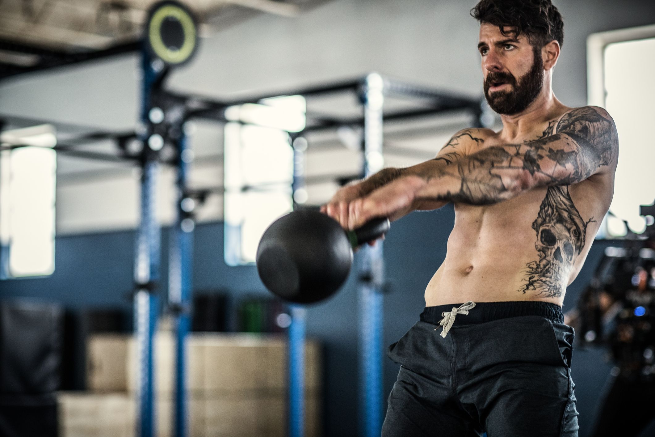Unrecognizable tattooed female athlete with heavy twelve kilogram weight  kettlebell on sports mat in gym Stock Photo | Adobe Stock
